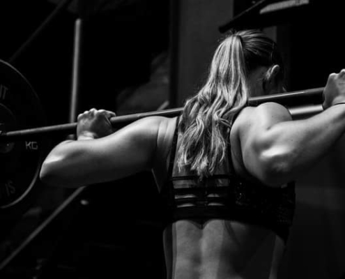 Frau mit Hantelstange im Nacken - Trainingsempfehlungen im Krafttraining Dogmen durchbrechen