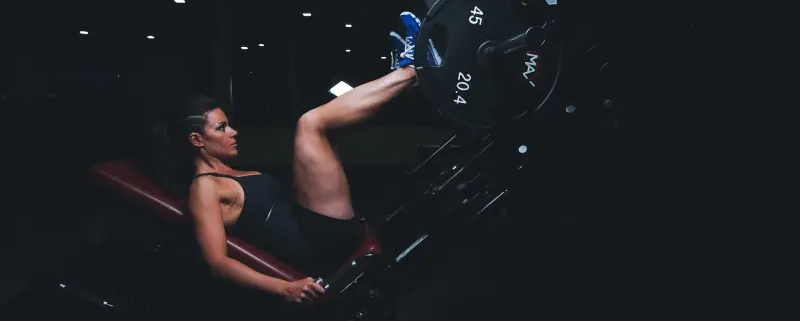 Frau auf Beinpresse: vastus medialis trainieren