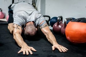 Mann bei Dehnung am Boden im Crossfit Training