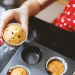 karotten mohn muffins in Frauenhand mit Muffinform